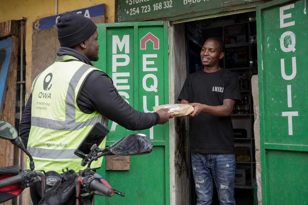 Rider exchanging a parcel with a merchant